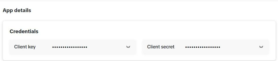 Bagian "App details" app AutoPost PT SKK: kartu "Credentials" berisi Client key dan Client secret yang tersembunyi (titik-titik) dengan ikon mata untuk menampilkannya.